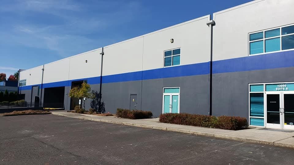 Commercial building exterior painted grey with a blue banding stripe