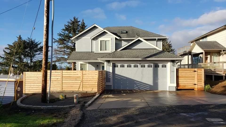 Light grey home with a new cedar fence and driveway