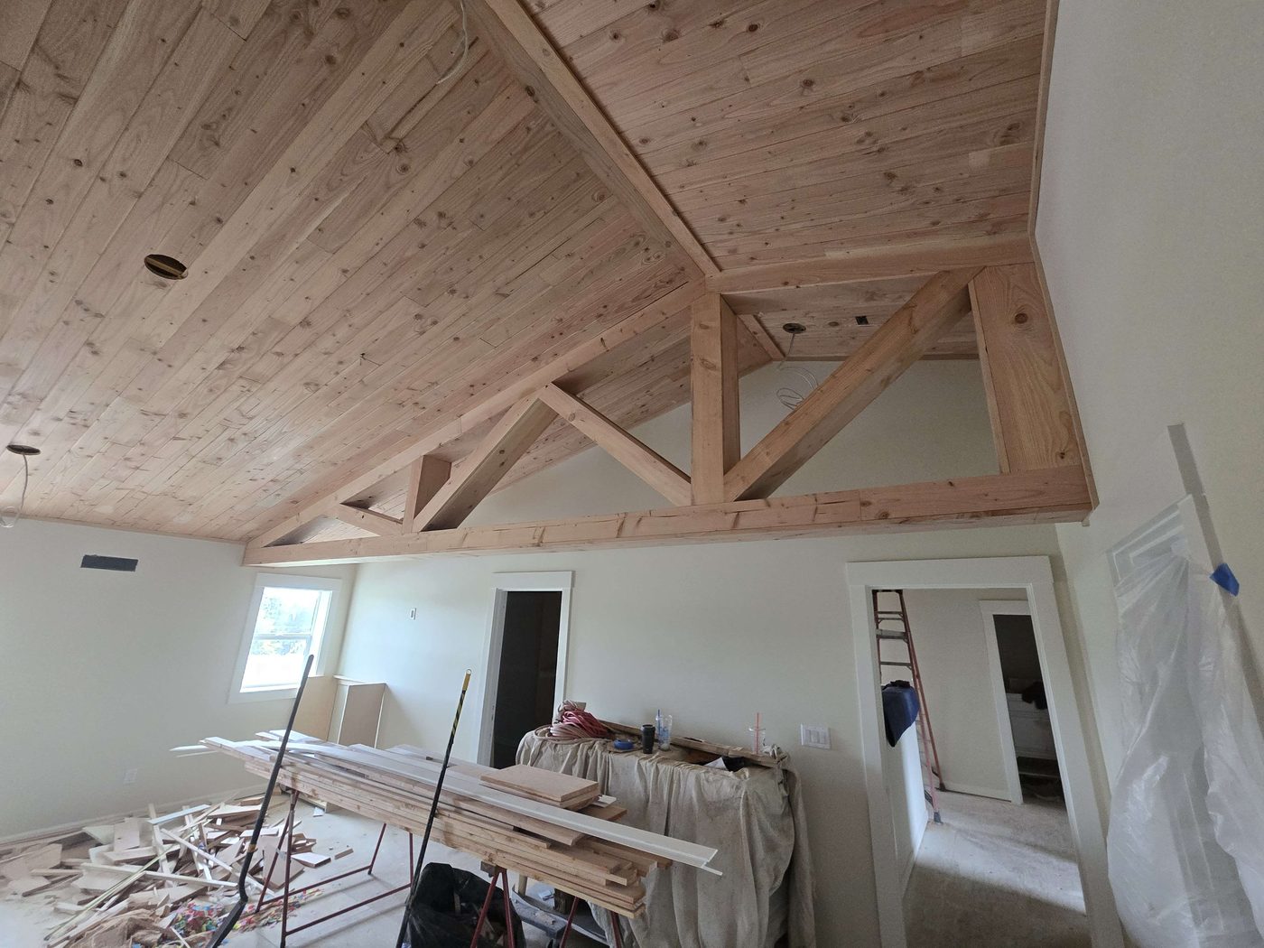 Vaulted tongue-and-groove ceiling and exposed timber trusses under construction