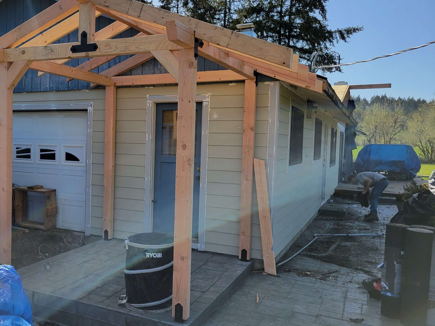 Timber-frame porch cover being built onto a garage entry